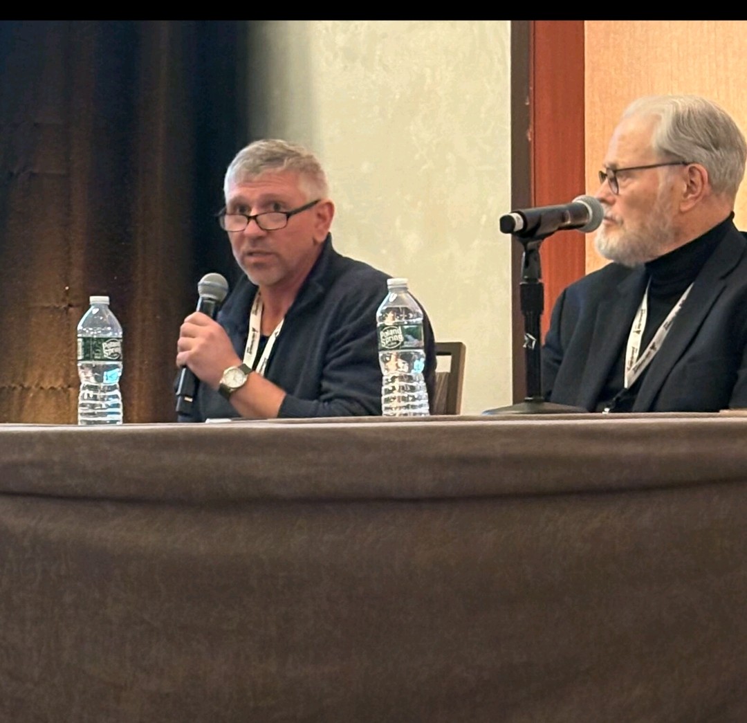 Marc McNeice speaking into a handheld microphone on the NASHIA panel